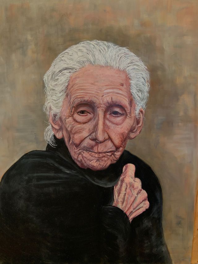 A realistic painting of the 96 year old Julia Prudencia Caballero Ortiz. She is looking forward and centered in the painting.